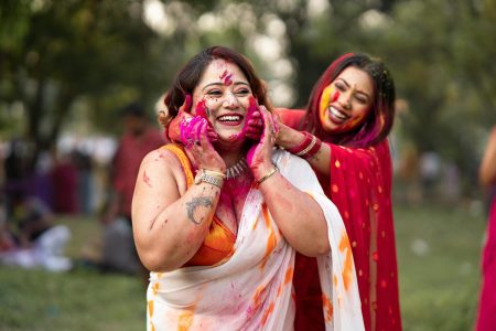 pexels-photo-31182126-31182126 Two women joyfully celebrate Holi with colorful powders in an outdoor setting in India.